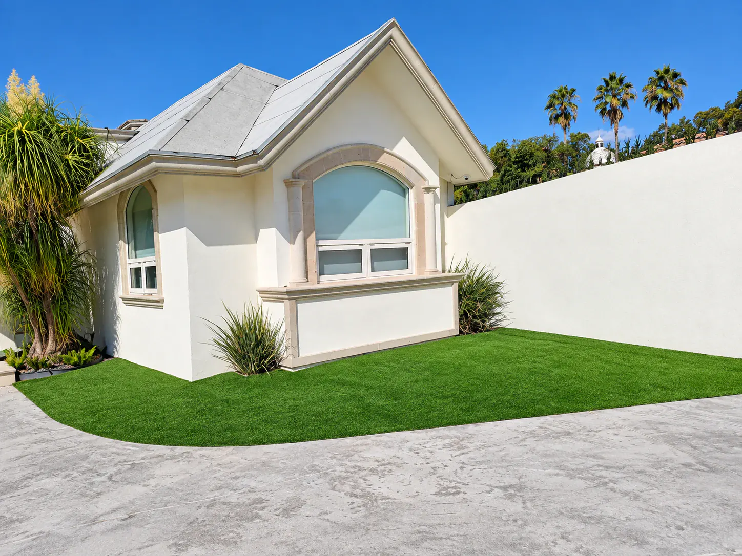 Acceso de vivienda con jardín de pasto sintético